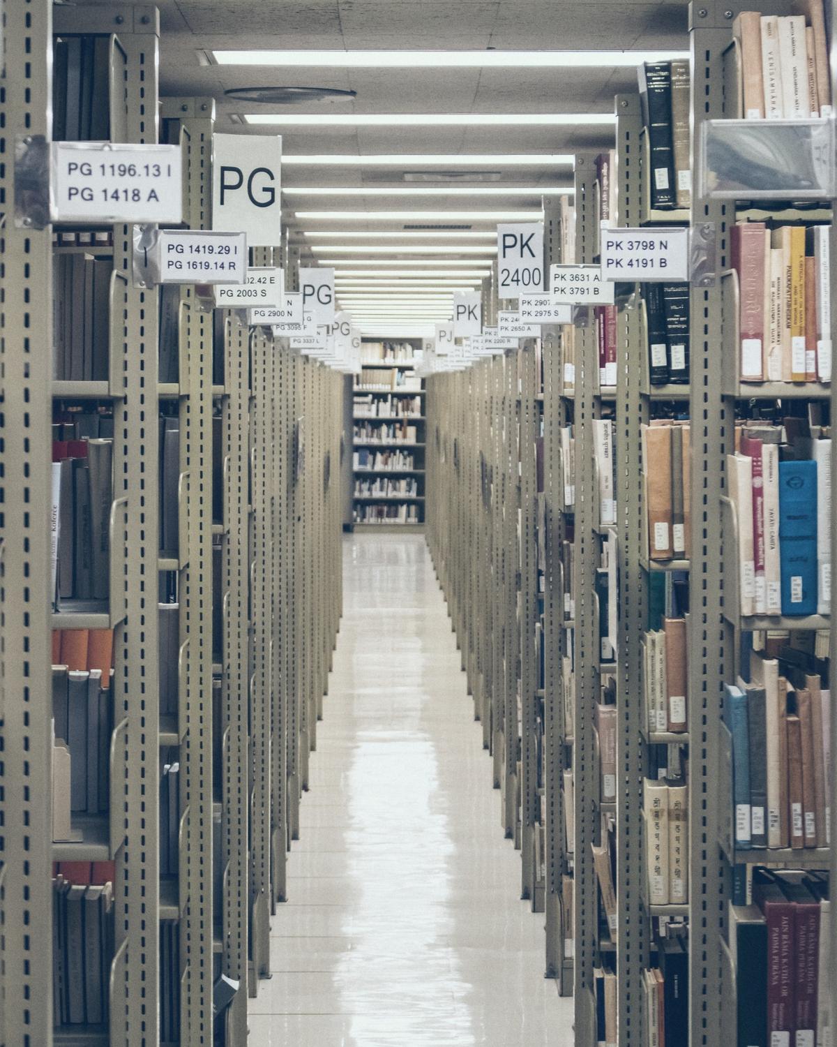 A long aisle of shelves loaded with files and binders.